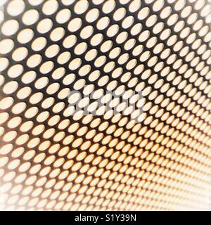 Abstract metallic background with holes blurring together in the distance. Stock Photo