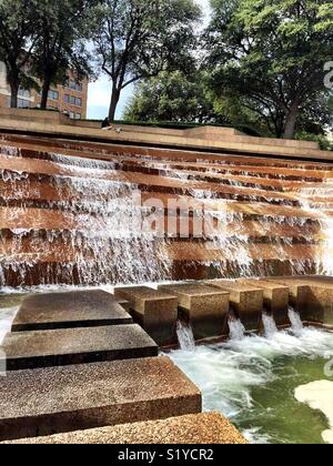 Water falls 38 feet over terraces into the eye of the active pool at the Fort Worth Water Gardens. The active pool has a path that allows visitors to experience the feel the heart of a cataract. Stock Photo