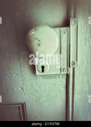 Old Victorian era painted door with marble doorknob and keyhole Stock Photo