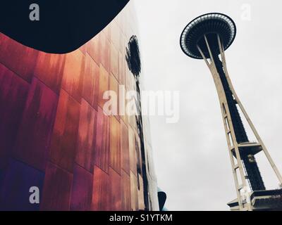 Iconic Space Needle in Seattle  reflecting in purple wall of MoPop museum designed by Frank Gehry Stock Photo