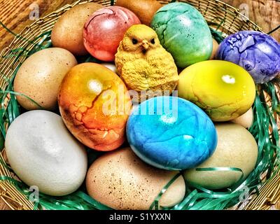 Easter chick statue with dyed and natural multicolored eggs Stock Photo