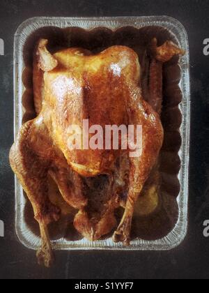 Flat view from above of freshly roasted golden brown turkey in an aluminum roasting pan Stock Photo