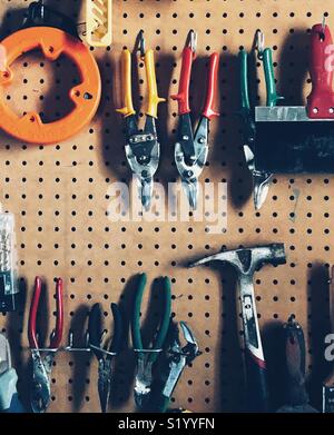 Pegboard full of random tools in a garage Stock Photo