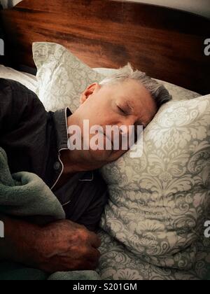 Senior man sleeping soundly in his bed, United States Stock Photo