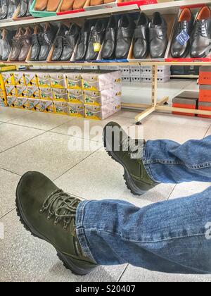 Trying on hiking boots in a Spanish shoe shop Stock Photo