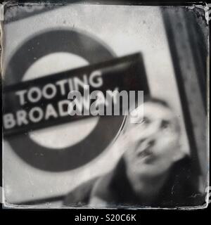 Man waiting for tube at Tooting Broadway station, London, England Stock Photo