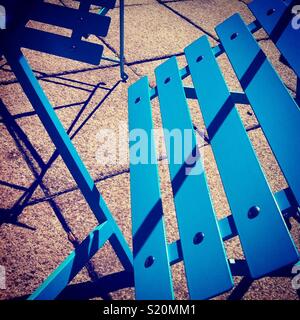 Blue Cafe Chairs create geometric shadows on a sunny day. Stock Photo