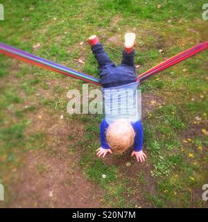Eighteen month old baby boy playing on a garden hammock, Hampshire,England,United Kingdom. Stock Photo