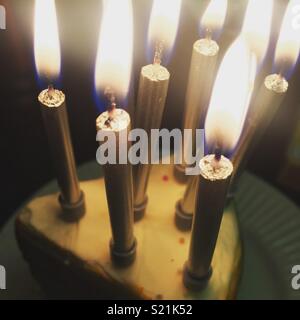 Silver birthday candles on a slice of birthday cake. Stock Photo