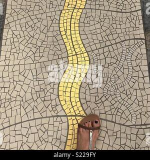 Foot on tile mosaic floor