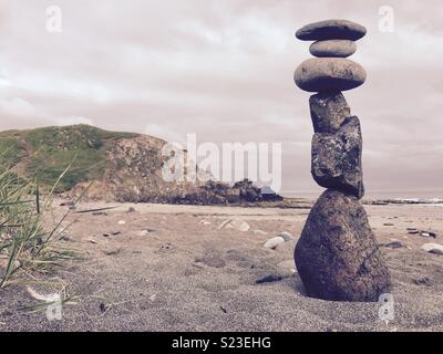 Balancing stone sculpture on beach. Stock Photo