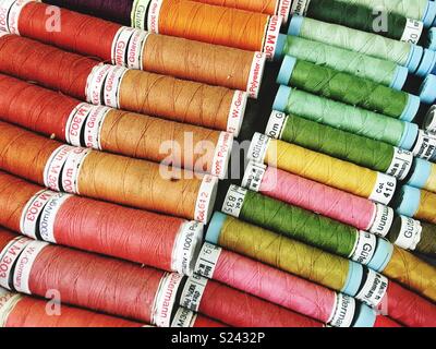 Roles of coloured sewing threads on display Stock Photo