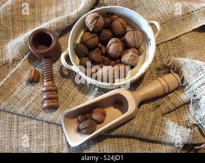 Elevated view on different nuts , nutcracker and vintage bowl on old sackcloth Stock Photo