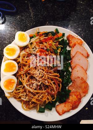 Large Sesame Chow Mein with boiled eggs and roast pork. Stock Photo