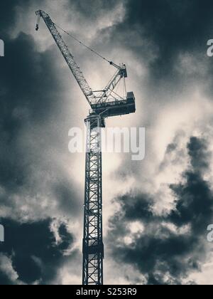 A crane on a construction site against a cloudy sky Stock Photo