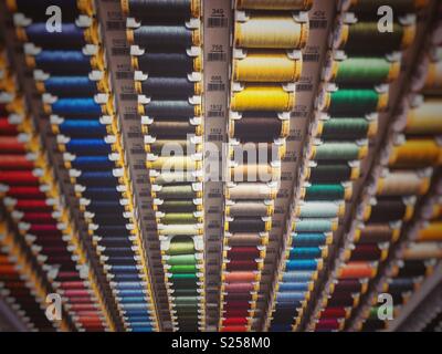 Rows of cotton thread on display stand in haberdashery Stock Photo