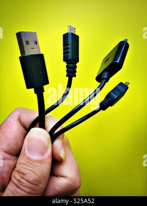 Hand holding myriad of different  USB and iPhone/ipad cable connection options. Stock Photo