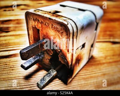 Fire damaged 3-way plug adapter (UK) Stock Photo