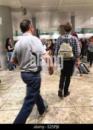 Travellers arriving in Alicante, collecting luggage from the baggage claim area of El Altea Airport, Spain Stock Photo