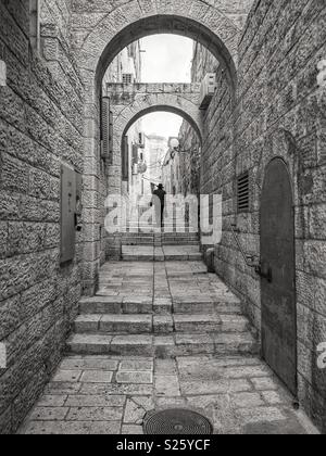 A Jewish man walks though an alley between buildings in the Jewish quarter of the old city in Jerusalem, Israel. Stock Photo