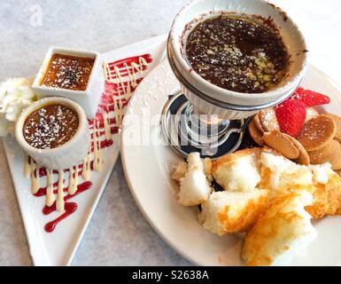 Dessert of creme brûlée and chocolate fondue with white cake, vanilla cookies and strawberries Stock Photo