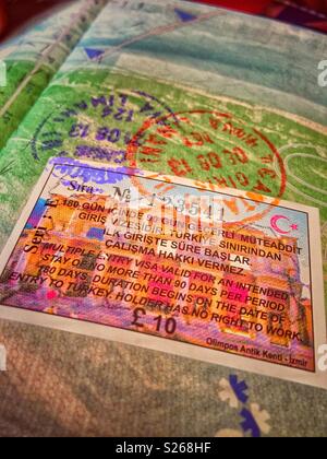 Macro photo of immigration stamps in British passport, showing stamps from the Turkish immigration authorities, together with a 'visa on arrival' payment receipt. Stock Photo