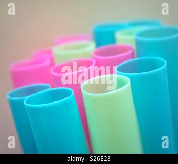 Macro closeup of brightly coloured blue, pink and greenish yellow plastic drinking straws Stock Photo