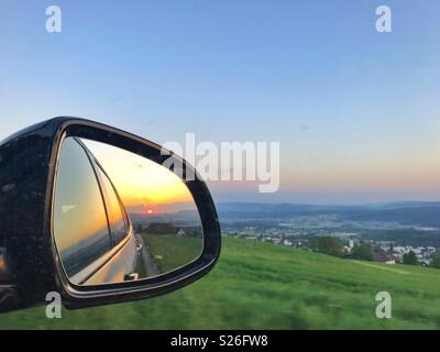 Sunset in the rear view mirror Stock Photo