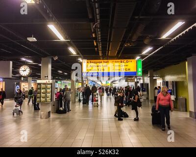 Airport scene. Passengers in a terminal of the Amsterdam-Schiphol airport. Stock Photo