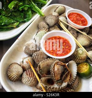 Clams and chilli sauce with gai lan and garlic at East Coast Lagoon Food Village, a hawker food market in Singapore Stock Photo