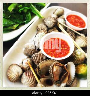 Clams and chilli sauce with gai lan and garlic at East Coast Lagoon Food Village, a hawker food market in Singapore Stock Photo