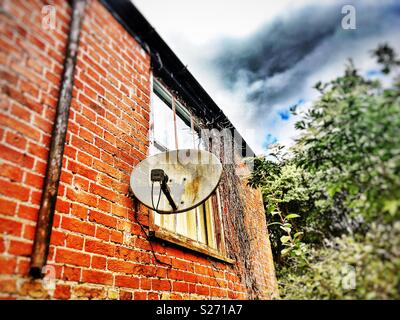 Satellite dish on the side of house Stock Photo