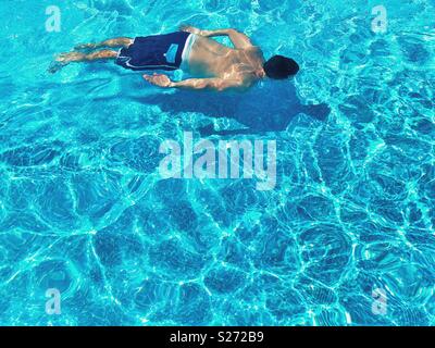 Man swimming under water in a swimming pool Stock Photo