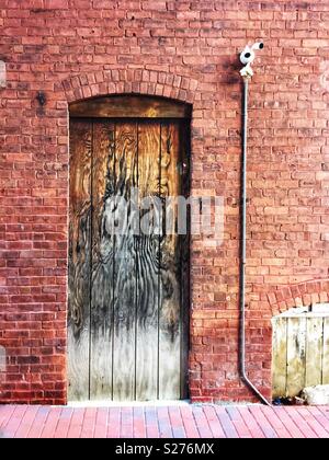 Old brick wall and wooden door  in an old alley way Stock Photo