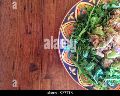 Healthy tuna salad lunch on colourful plate and wood table Stock Photo