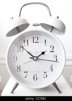 A traditional white alarm clock with bell and ringer Stock Photo