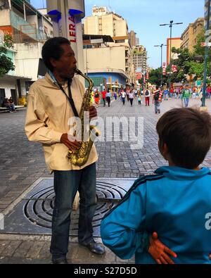 Sabana Grande Caracas Shopping. Man playing the saxophone. Caracas Venezuela. Marcos Kirschstein and Vicente Quintero. Stock Photo