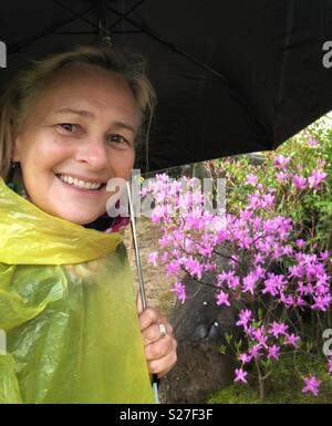 Woman standing under an umbrella at a Japanese Garden in Himeji, Japan. Stock Photo