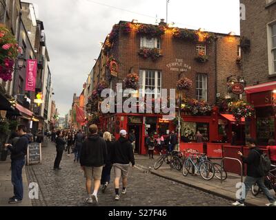 The Temple Bar Pub, est. 1840, in Dublin’s cultural quarter, famed for live music, flowers, and lively crowds on cobbled streets. Stock Photo