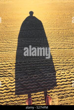 Funny shadow on the clean beach with tire tracks Stock Photo