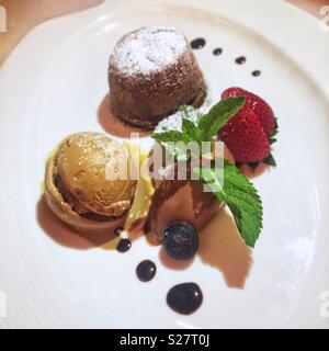 Liquid centre dark chocolate flan with espresso ice cream and strawberries, a dessert at Spasso Italian bar and restaurant, Tsim Sha Tsui, Kowloon, Hong Kong Stock Photo
