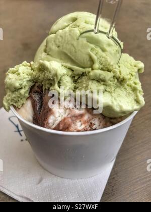 Two scoops of Ice cream in a take away plastic tub with a plastic spoon Stock Photo