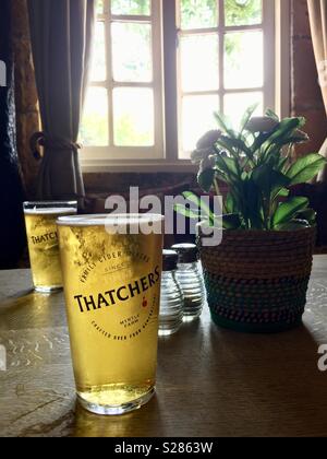 Drinking Thatchers apple cider at a pub at Stow-on-the-Wold, The Cotswolds, England UK Stock Photo