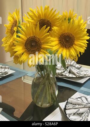 The sunflowers in a vase as the center piece on the dining room table Stock Photo