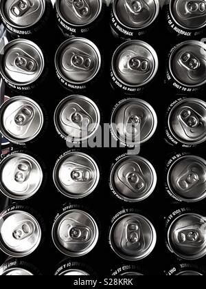 Looking down from above onto rows of unopened fizzy drinks cans or soda pop cans with ring pulls Stock Photo