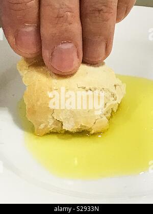 The bread dipped in olive oil with olive. Greek olive oil bread dip