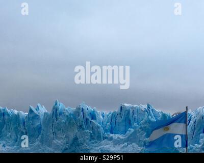 Perito Moreno glacier with Argentinian flag Stock Photo