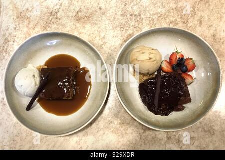 Chocolate brownie and sticky toffee pudding desert bowls together Stock Photo