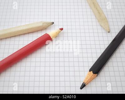 Pencils on a blank sheet of squared paper Stock Photo