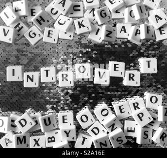 Introvert spelled out using letter squares.  To demonstrate how words can be hard to find sometimes.  Taken in black and white Stock Photo